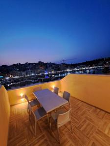 een tafel en stoelen op een balkon met uitzicht bij B&S Accommodation Seafront Duplex Penthouse in Marsaskala