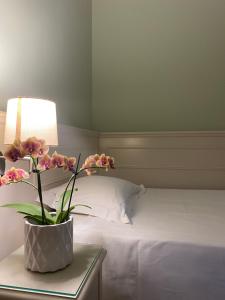 a bedroom with a bed with a vase of flowers on a table at Hotel Aquila in Castelfranco Emilia