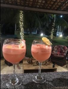 twee cocktails in glazen zittend op een tafel bij Casa de praia Beira-mar in Estância