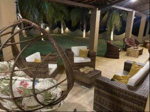 een woonkamer met rieten stoelen en een patio bij Casa de praia Beira-mar in Estância