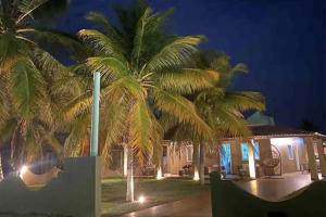 een huis met twee palmbomen ervoor bij Casa de praia Beira-mar in Estância