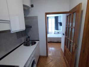 a kitchen with a sink and a door to a bedroom at Estudio - Puerta del Sol in Madrid
