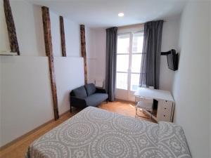 a bedroom with a bed and a chair and a window at Estudio - Puerta del Sol in Madrid