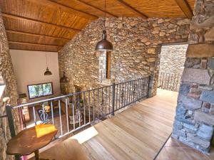 Habitación con pared de piedra y balcón. en Can Carreres - Un lloc on desconnectar en família, en El Pasteral