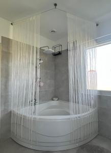 eine Badewanne mit Duschvorhang im Bad in der Unterkunft The Private House in Siófok