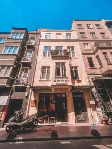 un scooter estacionado frente a un edificio alto en New Pera Hotel, en Estambul