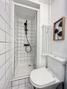 y baño blanco con aseo y ducha. en Le Toucan - Joli studio proche Tram & centre-ville, en Toulouse