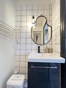 y baño con lavabo, espejo y aseo. en Le Toucan - Joli studio proche Tram & centre-ville, en Toulouse