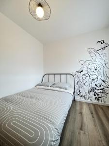 Dormitorio blanco con cama y pared en Le Toucan - Joli studio proche Tram & centre-ville, en Toulouse