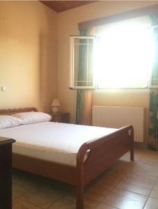 a bedroom with a large bed with a window at Farmhouse in Volimes