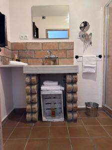 a bathroom with a brick fireplace under a sink at L'Olivera Casa Rural in Castellbisbal