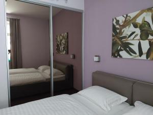 a mirror in a bedroom with a bed at App OLIVE Old Town in Poreč