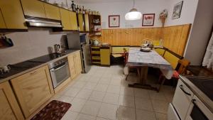 eine Küche mit einem Tisch in der Mitte in der Unterkunft Casa della Rosina in Bresimo