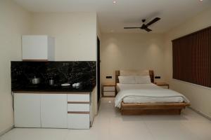 Stay10 Premium Service Apartments في إندوري: غرفة نوم بسرير ومروحة سقف