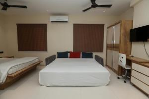 a bedroom with two beds and a flat screen tv at Stay10 Premium Service Apartments in Indore