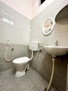 a bathroom with a toilet and a sink at VHB Inn in Jigani