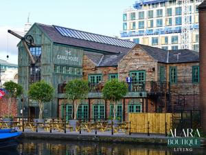 a building next to the water with tables and chairs at Luxury 3 Floor Townhouse Birmingham - Alara Boutique Living in Birmingham