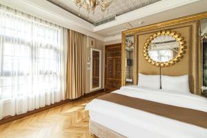 Un dormitorio con una cama grande y una lámpara de araña. en Sakine Hanim Mansion en Estambul