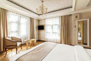 Un dormitorio con una cama grande y una lámpara de araña. en Sakine Hanim Mansion, en Estambul