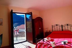 1 dormitorio con cama roja y puerta corredera de cristal en Intera casa con due stanze nel Parco del Cilento, en Piaggine