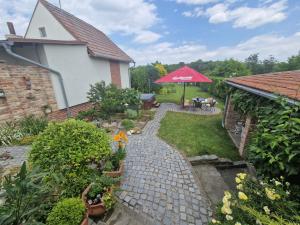 un jardín con un edificio de ladrillo y una sombrilla en Ubytovani Klára, en Bulhary