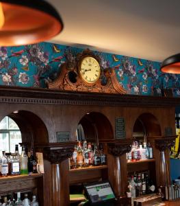a large clock on a wall above a bar at Loch Lomond Hotel in Balloch