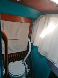 a small bathroom with a toilet and a window at Dormir sur un bateau in Cap d'Agde