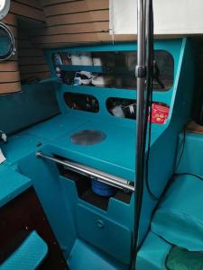 an interior of an rv with blue walls and counters at Dormir sur un bateau in Cap d'Agde