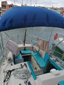 a boat with blue seats on a body of water at Dormir sur un bateau in Cap d'Agde