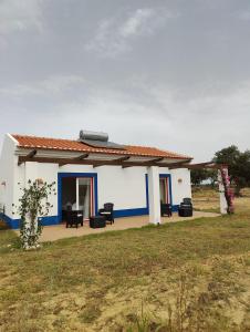 - un bâtiment blanc et bleu avec une table et des chaises dans l'établissement Monte da Isabel, à Vale de Água