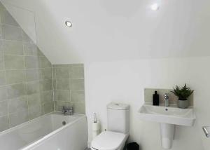a bathroom with a white toilet and a sink at Luxurious new built kingsize bedroom in Manchester