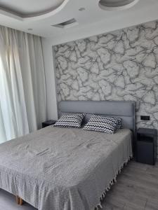 a bedroom with a large bed with a stone wall at Uğur Apart Sea View in Erdemli