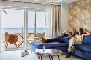 un uomo e una donna seduti su un divano blu in un soggiorno di Expoholidays- Apartaments Paseo Marítimo a Almería