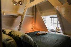 een kleine kamer met een bed en een raam bij Appartement ‘t-Yesenaertje in Yerseke