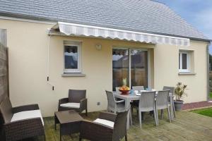 a patio with a table and chairs and a house at Baie du Mont Saint Michel / Gîte de la Vaquerie 23 in Vains