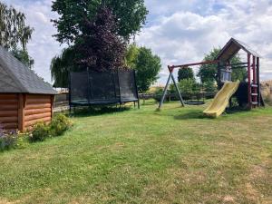 un parque con un parque infantil con un tobogán y una pista en Ferienwohnung Sunshine vom Friesenhof Wieratal, 