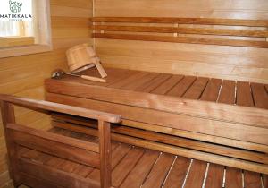 bañera de madera con banco en una habitación en Matikkala Cottages, en Ruokolahti