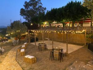 a patio with tables and chairs and lights at L'Olivera Casa Rural in Castellbisbal