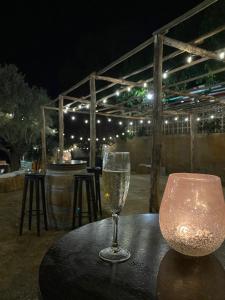 a glass of wine sitting on a table with a lamp at L'Olivera Casa Rural in Castellbisbal