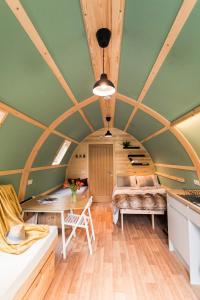 um quarto com um tecto de madeira com uma mesa e um sofá em Wigwam Holidays Forcett Grange em Richmond
