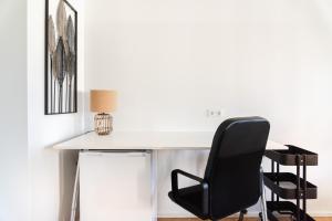 a white desk with a black chair and a lamp at Hybrid Work-Play Retreat - 2BR, 1B central Kreuzberg in Berlin