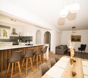 een keuken en een woonkamer met een bar en stoelen bij Villa Zou in Ambelas
