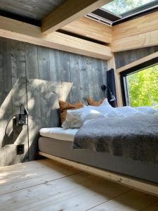 a bedroom with a bed in a wooden wall at Fuglekassehytta 