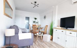uma sala de estar com um sofá e uma televisão em Sublime sea view apartement em Calafell