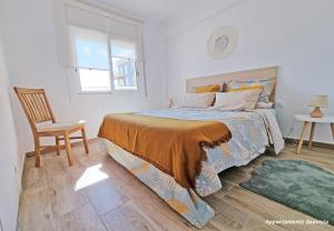 a bedroom with a bed and a chair and a window at Sublime sea view apartement in Calafell