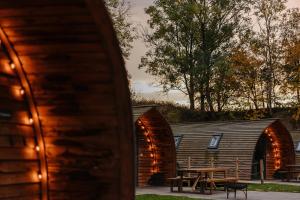 a group of wooden buildings with a picnic table in front at Wigwam Holidays Forcett Grange in Richmond