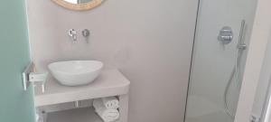 a white bathroom with a sink and a shower at Ilias Place in Ios Chora