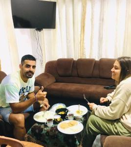 un grupo de personas sentadas alrededor de una mesa comiendo comida en Ansi Villa en Nanu Oya