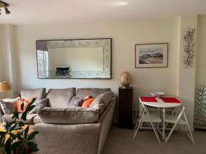 ein Wohnzimmer mit einem Sofa und einem Tisch in der Unterkunft 2 Bedroom Apartment in Central Windsor in Windsor