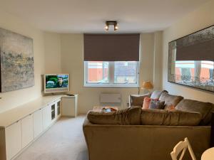 2 Bedroom Apartment in Central Windsor في ويندسور: غرفة معيشة مع أريكة وتلفزيون
